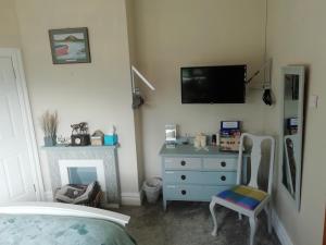 um quarto com uma cama, uma cómoda e uma televisão em Creevy Annex - 2 bedroom Self Catering Accomodation em Rake Street
