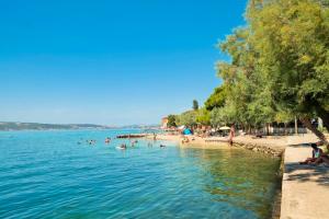 a group of people in the water at a beach at Gemini Suites in Kaštela