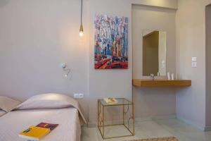 a bedroom with a bed and a painting on the wall at Nissi Collection Rooms in Argasi