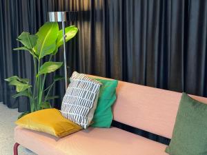 a couch with pillows on it next to a plant at Isabella Living in Maribor