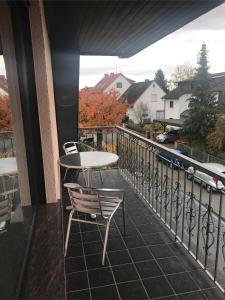 eine Terrasse mit einem Tisch und Stühlen auf dem Balkon in der Unterkunft Für Pendler und Monteure oder Ferienwohnung zum Erholen in Ober-Ramstadt