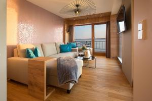 ein Wohnzimmer mit einem Sofa und einem TV in einem Zimmer in der Unterkunft Hotel Restaurant Seehalde in Uhldingen-Mühlhofen