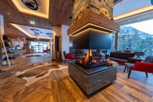 a living room with a fireplace in the middle at Nationalpark Chalets Neukirchen in Neukirchen am Großvenediger