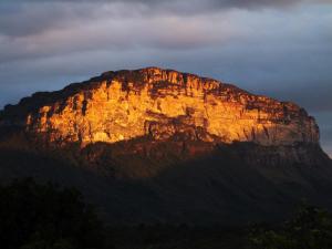 una montaña con el sol brillando en ella en Dormitório - Hospedagem Caminho da Angélica, en Vale do Capao