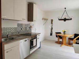 a kitchen with white cabinets and a wooden table at La Casa Suciu in Forchtenberg