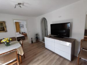 a living room with a flat screen tv on a cabinet at La Casa Suciu in Forchtenberg