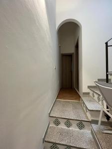 un couloir avec des escaliers et une porte dans un bâtiment dans l'établissement Sagra Vacanze Cinisi, à Cinisi
