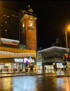 a large clock tower with a clock on it at "Snooze Central" - above Victoria Centre Shopping Centre - most Central Location on Milton Street next to the Hilton Hotel - Apartments with up to 4 Beds - Cook as you would at Home - Outdoor Parking for Cars or Vans at five pounds a day in Nottingham