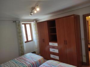 1 dormitorio con 1 cama, armario y ventana en Apartamento Toki Berriya en Elizondo