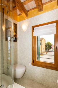 ブラーノにあるTIFFANY GOLDのバスルーム(トイレ、ガラス張りのシャワー付)