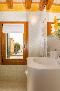 TIFFANY GOLD في بورانو: حمام مع حوض ونافذة ومغسلة