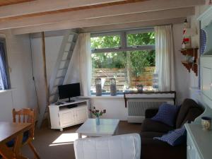 ein Wohnzimmer mit einem Sofa und einem Fenster in der Unterkunft Vloed in Callantsoog