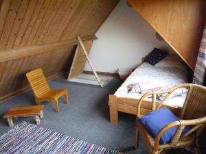 ein kleines Dachzimmer mit einem Bett und einem Stuhl in der Unterkunft Vloed in Callantsoog