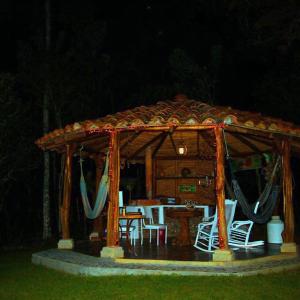 a wooden gazebo with a table and chairs in it at La Cabaña Encantada in Támesis