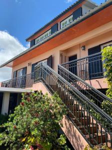 an apartment building with a balcony and a tree at La Villa du Volcan in Le Tampon