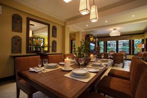 a dining room with a wooden table and chairs at Villa Senja in Tanah Lot