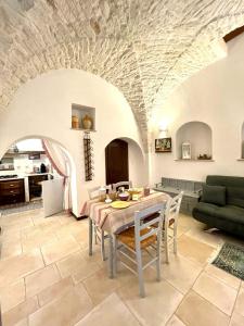 a dining room with a table and chairs in a living room at Luxury Trulli Sabotino 48 in Alberobello +20 photos