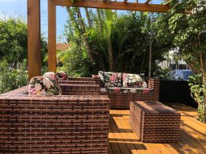 佛羅安那波里的住宿－Suítes Jurerê Internacional，木制甲板上设有砖砌露台,配有沙发和椅子
