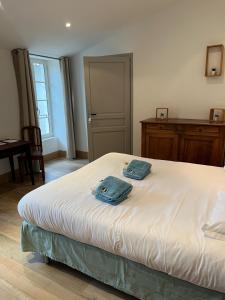 a bedroom with a bed with two towels on it at Les voiles rouges in Saint-Martin-de-Ré