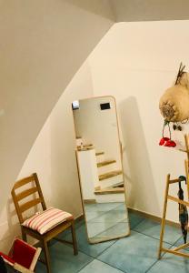 un espejo sentado junto a una silla en una habitación en IL MELOGRANO La Casa nel Vicoletto en Lanciano