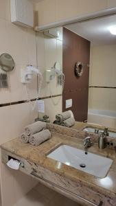 bagno con lavandino e grande specchio di Apartment Residence Marina Portorož LEVANT 203 a Portoroz