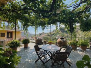 eine Terrasse mit einem Tisch und Stühlen mit Aussicht in der Unterkunft Rodous Village House in Limassol
