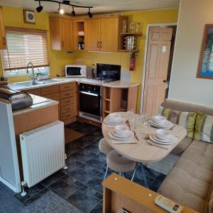 a kitchen with a table with dishes on it at 2-Bed Caravan at Billing Aquadrome Northampton in Northampton