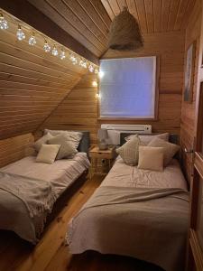 a room with two beds in a wooden cabin at Przystanek Tonkiele in Tonkiele