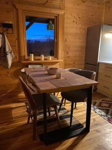 a wooden table and chairs in a kitchen with a window at Przystanek Tonkiele in Tonkiele