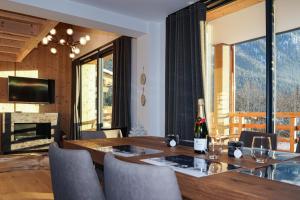 a dining room with a table with a bottle of wine at La Cordee 623-Luxury apartment with mountain view and SPA in Chamonix-Mont-Blanc