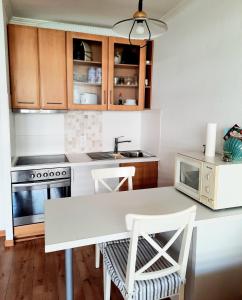 a kitchen with a white table and a microwave at Apartment 3 Minuten zu Fuss zum Meer (40m²) in Lübeck