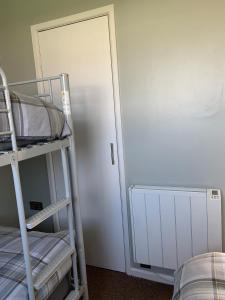 a room with two bunk beds next to a door at Modern 2 Bed Chalet - 27 Bermuda Holiday Park in Hemsby