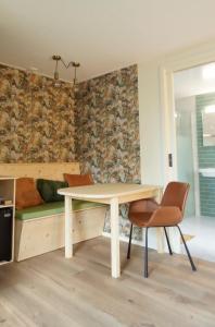 uma sala de jantar com uma mesa e um sofá em Bed and Breakfast het Groentje em Staphorst
