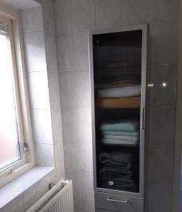 a bathroom with a glass cabinet with towels at Bed and Breakfast het Groentje in Staphorst +2 photos