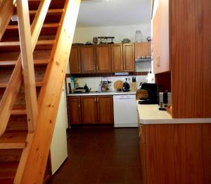 a kitchen with wooden cabinets and a staircase at Pronájem chalupy Seč-Rostejn in Drhotín