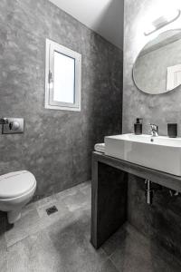 a bathroom with a sink and a toilet and a mirror at Boutique Studios & Apartments - by Avelink in Spáta