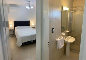 a bedroom with a bed and a bathroom with a sink at Dpto Lyon in General Roca