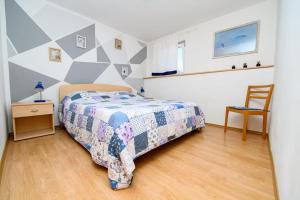 een slaapkamer met een bed, een tafel en een stoel bij Apartmani Noris (app3) in Martinšćica