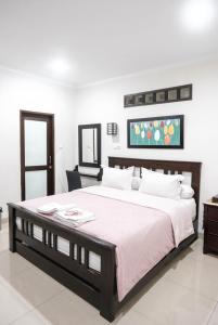 a bedroom with a large bed and a table at Pasola Guest House in Medan