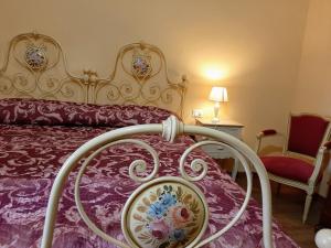 a bedroom with a bed with a purple comforter at Bed & Breakfast La Casa Antica in Macomer