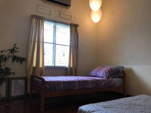 ジョホールバルにあるCosy big house 5min CIQ SOGO KSL mall 4BR 12Paxのベッドと窓のある寝室