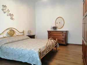 a bedroom with a bed and a mirror and a dresser at La Dimora degli Olivi in Torrita di Siena