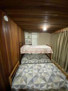 1 dormitorio pequeño con 1 cama en una casa pequeña en Casa anexa com lareira, en Campos do Jordão