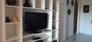 telewizor siedzący na białej półce w salonie w obiekcie Málaga, Mijas, La Cala, apartamento vacaciones de ensueño w mieście La Cala de Mijas
