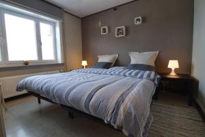 1 dormitorio con 1 cama grande y 2 lámparas en Molenbergrust, en Zwalm