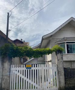 una cerca blanca frente a una casa en Casa anexa com lareira, en Campos do Jordão