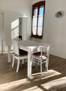 una mesa blanca y sillas en una habitación en "La Cascina" Bed & Breakfast, en Desenzano del Garda