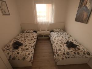 two beds in a small bedroom with a window at Apartment Gloria in Peroj