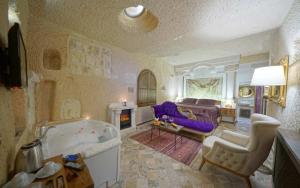 a large living room with a tub and a couch at Arte Cave Hotel in Urgup