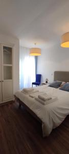 a bedroom with a large bed and a blue chair at Casa na Costa in Costa Nova